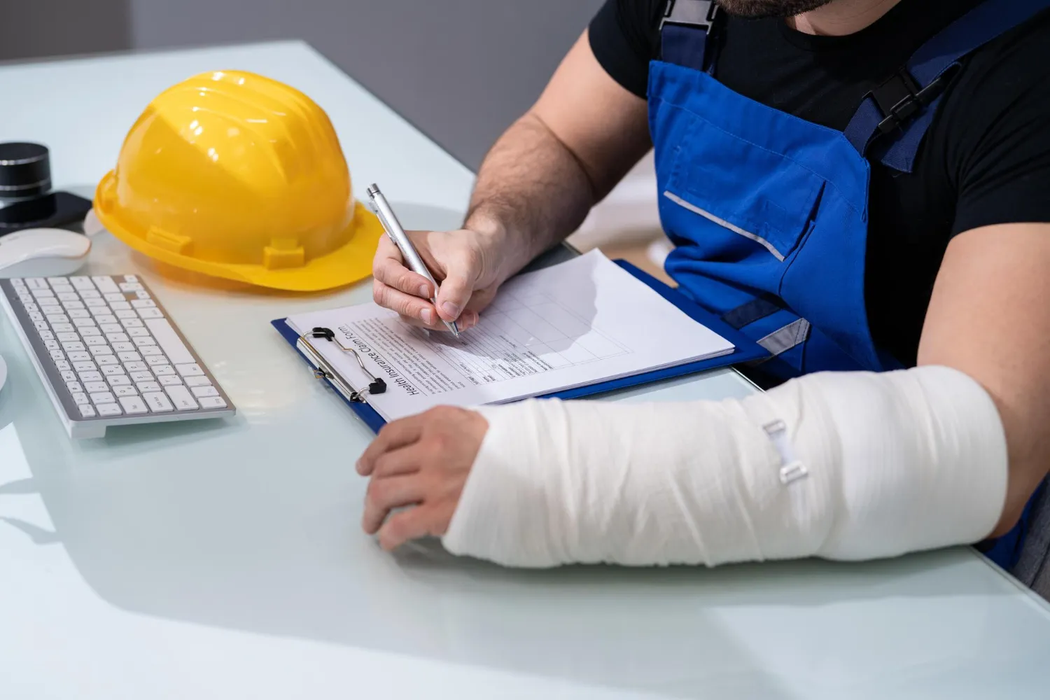 Injured worker with a cast completing workplace injury documentation after receiving treatment at one of the injury care centers in Jacksonville, supporting proper reporting, medical care, and recovery.