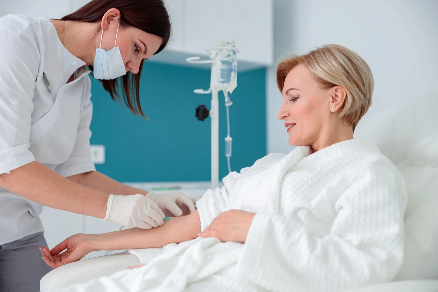 Patient receiving IV hydration therapy from a medical professional during wellness and recovery care session