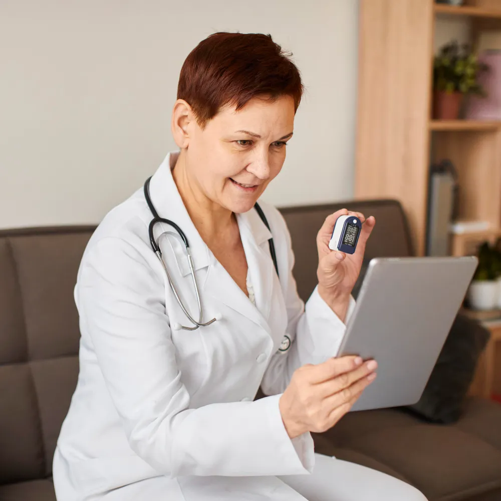 Doctor conducting a remote checkup using a tablet and monitoring device, showcasing the role of a telemedicine doctor and advanced support through a virtual health assistant in modern telemedicine Jacksonville FL care