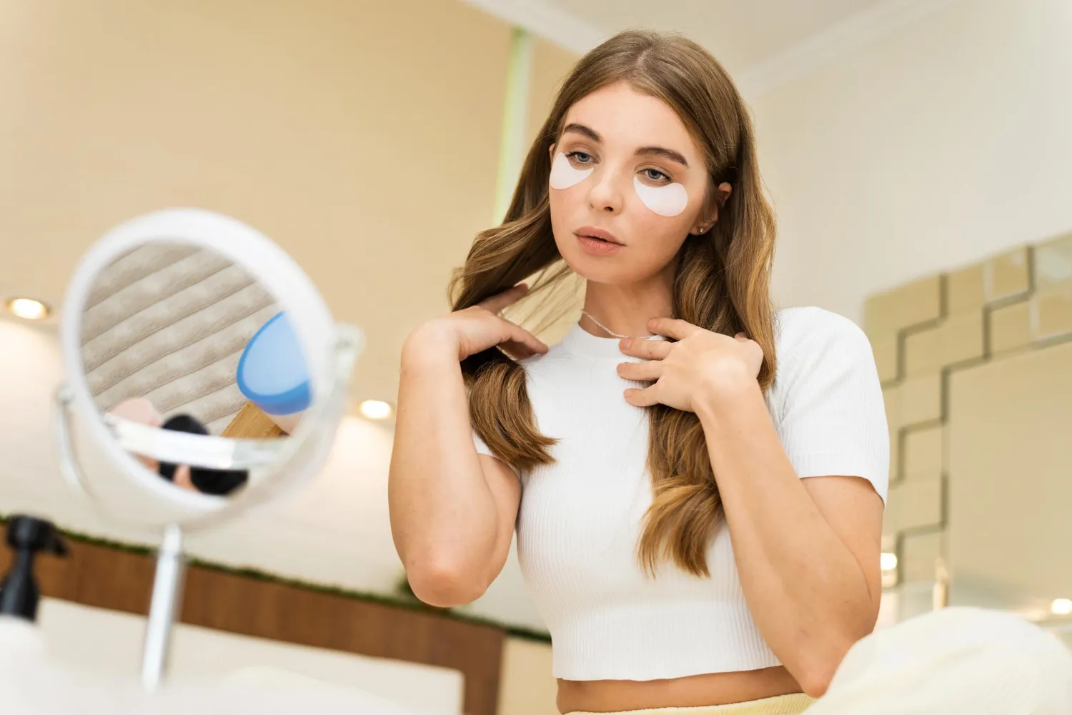 Young woman applying under-eye patches as part of a skincare routine, highlighting services offered at a dermatology center in Jacksonville focused on skin health and rejuvenation