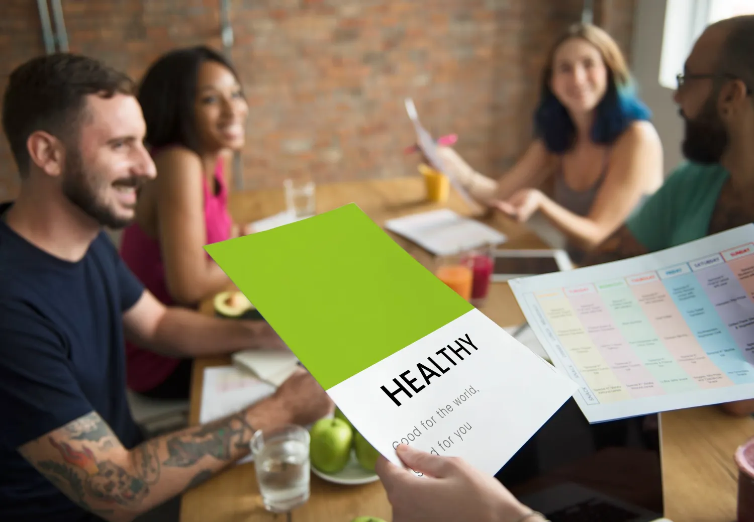 A group reviewing a “Healthy” lifestyle guide together, representing proactive wellness physicals, wellness health check up, and comprehensive wellness health assessment planning