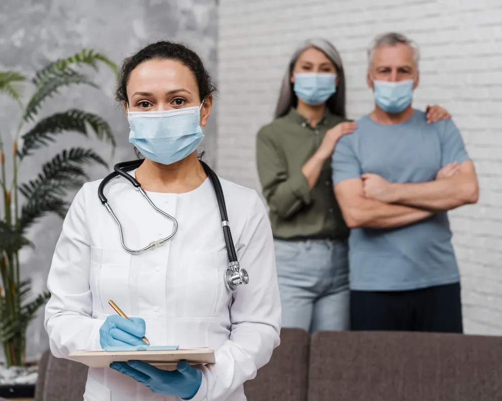 Family care physician wearing mask and stethoscope consulting patients during routine checkup at primary care clinic