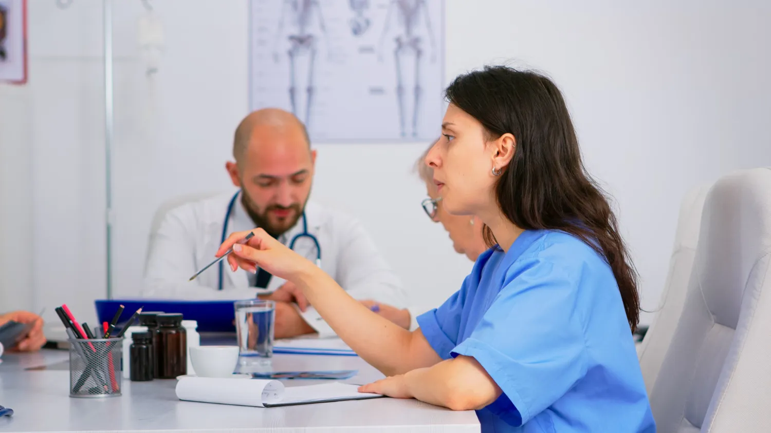 Healthcare professionals discussing patient care plans, highlighting collaborative treatment approaches by an experienced internal medicine physician and support for complex health needs