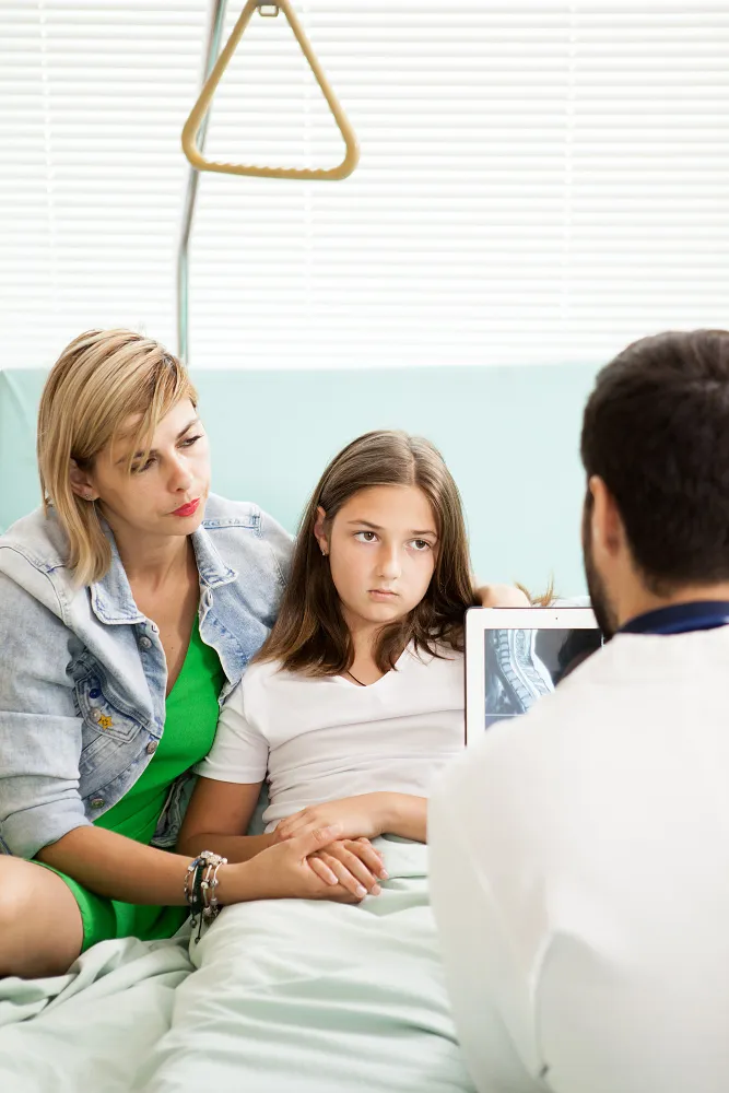 Mother and child consulting doctor at primary care clinic for routine checkup at trusted family medical clinic