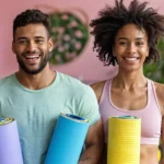 A smiling couple holding yoga mats, representing the importance of regular wellness physicals, preventive care, and maintaining an active, healthy lifestyle through consistent wellness health check ups and fitness routines