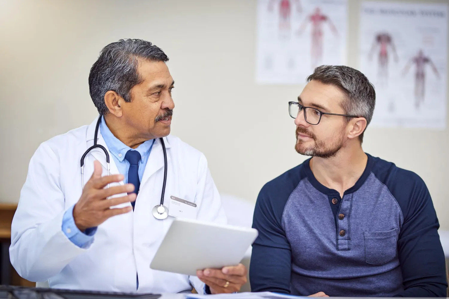 A doctor discussing health concerns with a male patient, representing a professional men’s health clinic and routine men’s health checkup services in Jacksonville