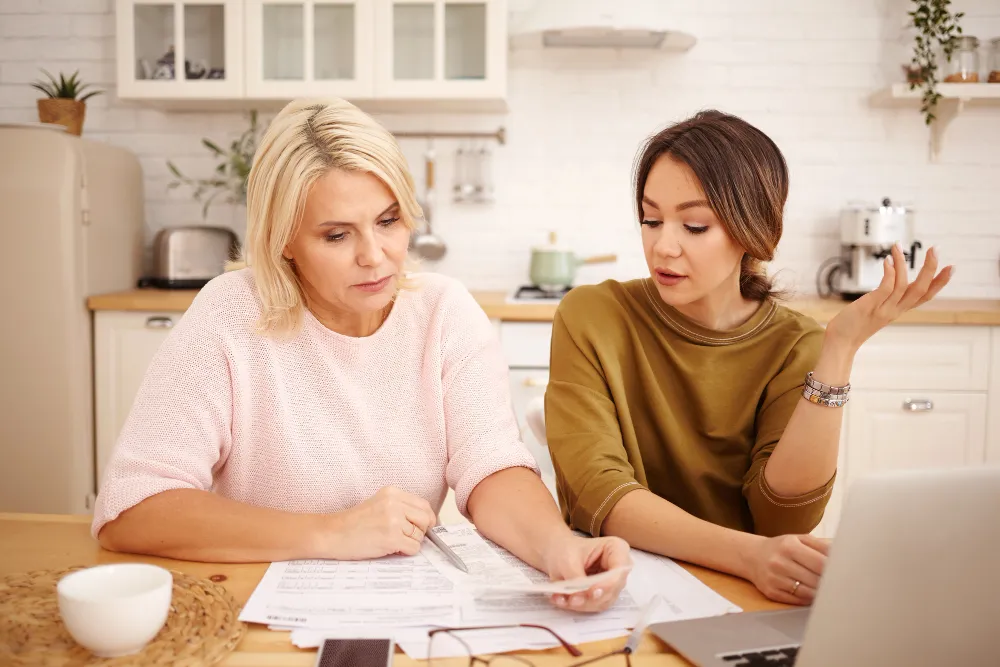 Female patient reviewing medical bills and discussing women’s primary care services with a healthcare professional