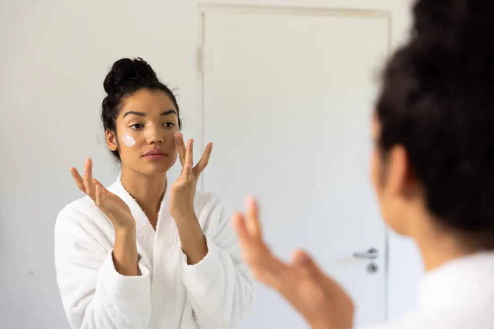Woman applying facial cream at home following advice from skin specialist Jacksonville for healthy skincare routine
