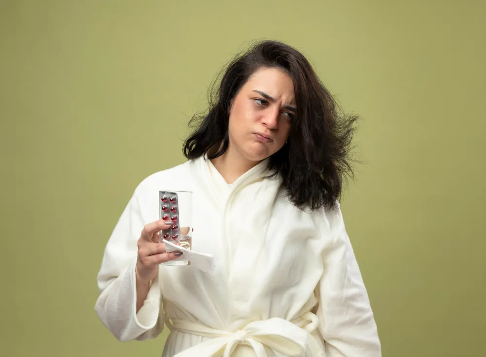 Woman holding medication and showing discomfort, representing hormonal imbalance treatment and women’s health support in Jacksonville