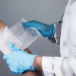Medical professional applying bandages to a patient’s arm, representing services offered at an outpatient wound care clinic focused on proper wound care treatment and faster healing
