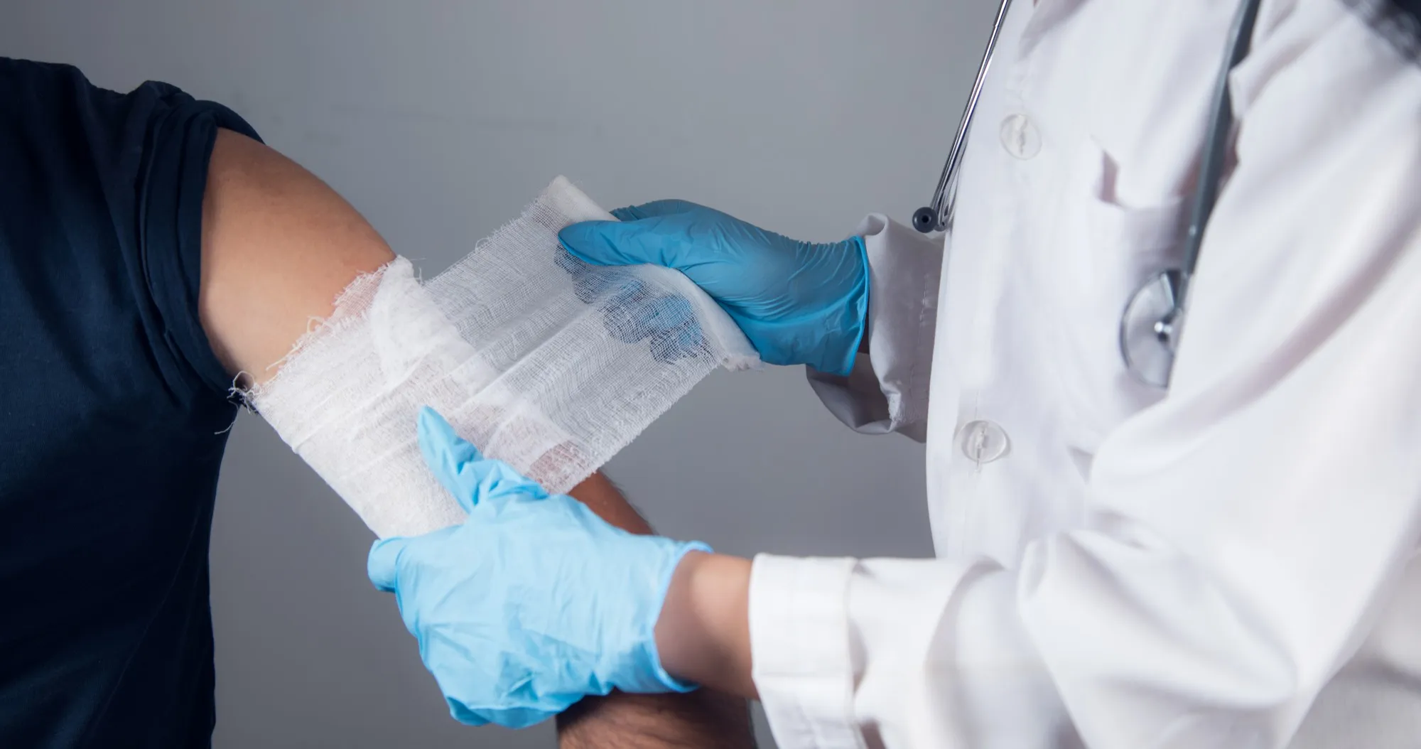 Medical professional applying bandages to a patient’s arm, representing services offered at an outpatient wound care clinic focused on proper wound care treatment and faster healing