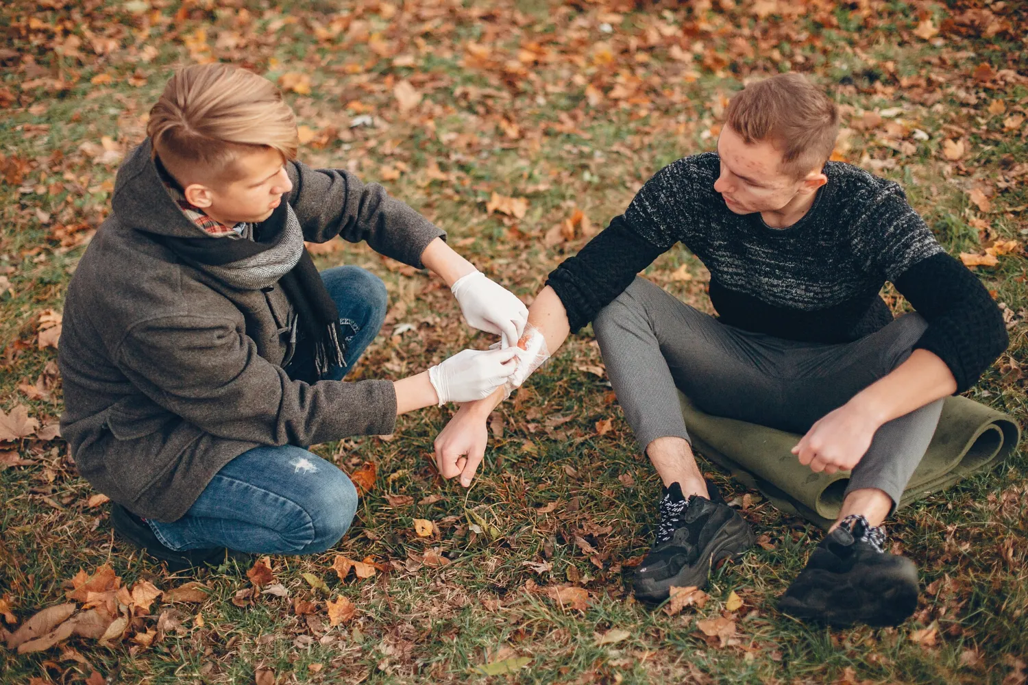 First aid being administered outdoors to an injured individual, emphasizing the importance of timely care through a wound care center and structured wound treatment program, especially for conditions like diabetic foot ulcers