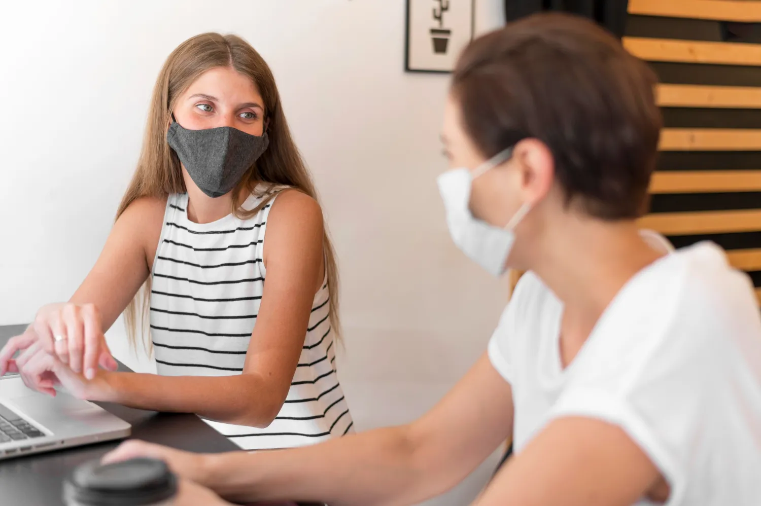 Two individuals wearing masks having a consultation, illustrating a safe and private environment for STD clinic visits and confidential STD testing and treatment services