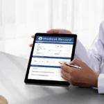 Primary care clinic physician reviewing digital medical records with patient during healthcare consultation