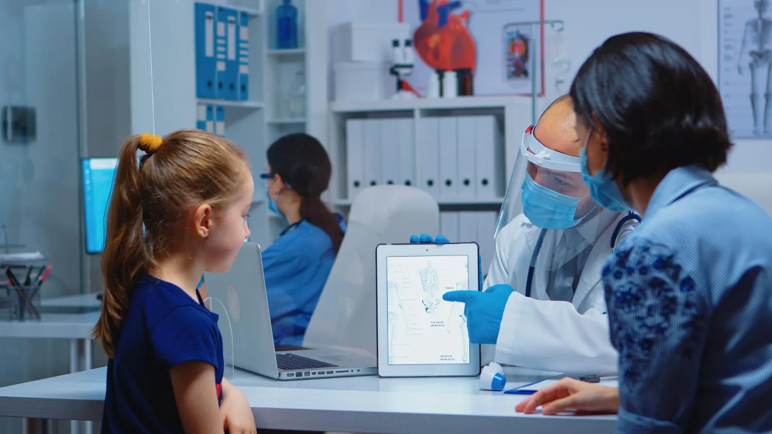 Primary care clinic doctor consulting with parent and child during pediatric healthcare appointment in Jacksonville