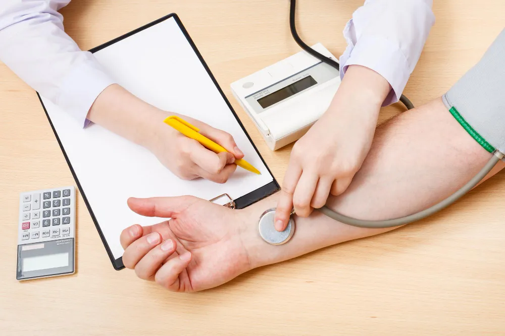 Healthcare provider checking patient blood pressure during routine examination at a primary care clinic