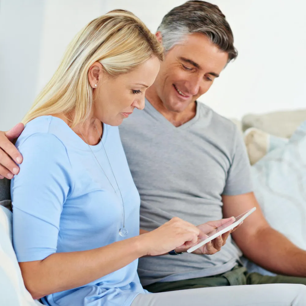 Woman reviewing IV therapy information on a tablet while seated with a companion, representing IV therapy in Jacksonville, FL, patient education, and informed treatment decisions before booking an IV infusion.