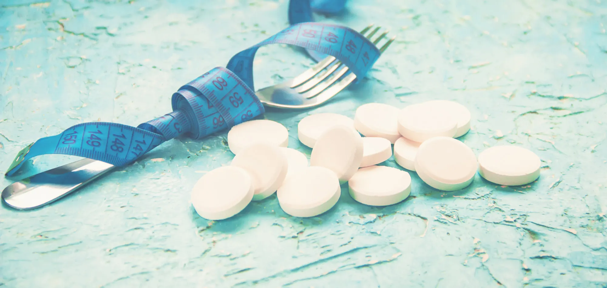 Tirzepatide vs semaglutide weight loss medications with a measuring tape and pills, illustrating options for weight management treatment.
