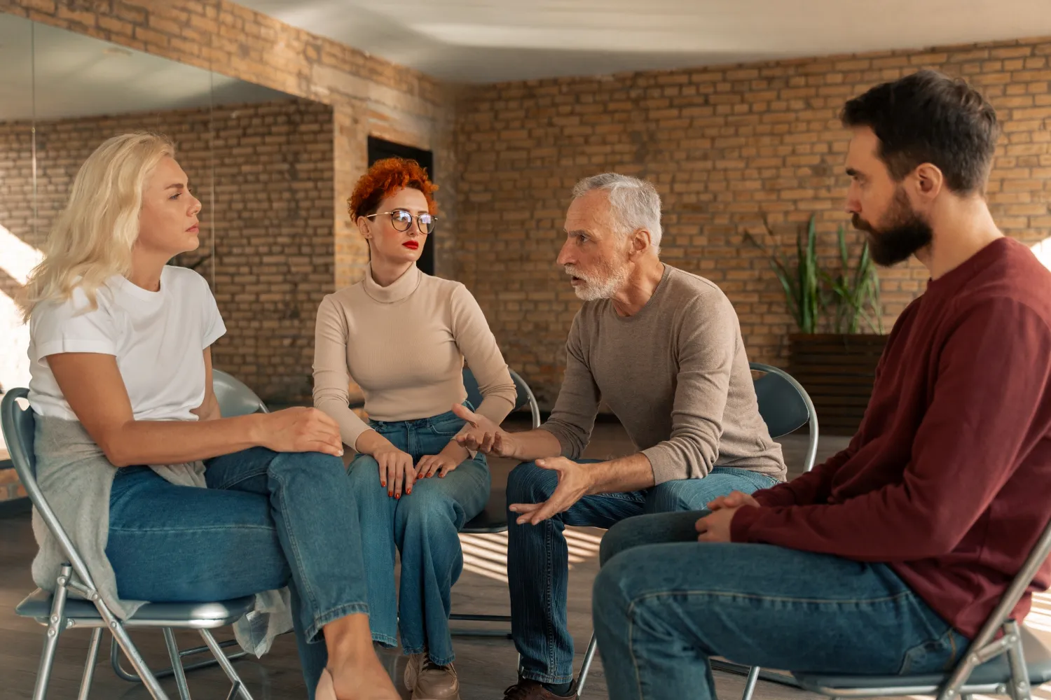 Group therapy session with adults discussing mental health concerns.