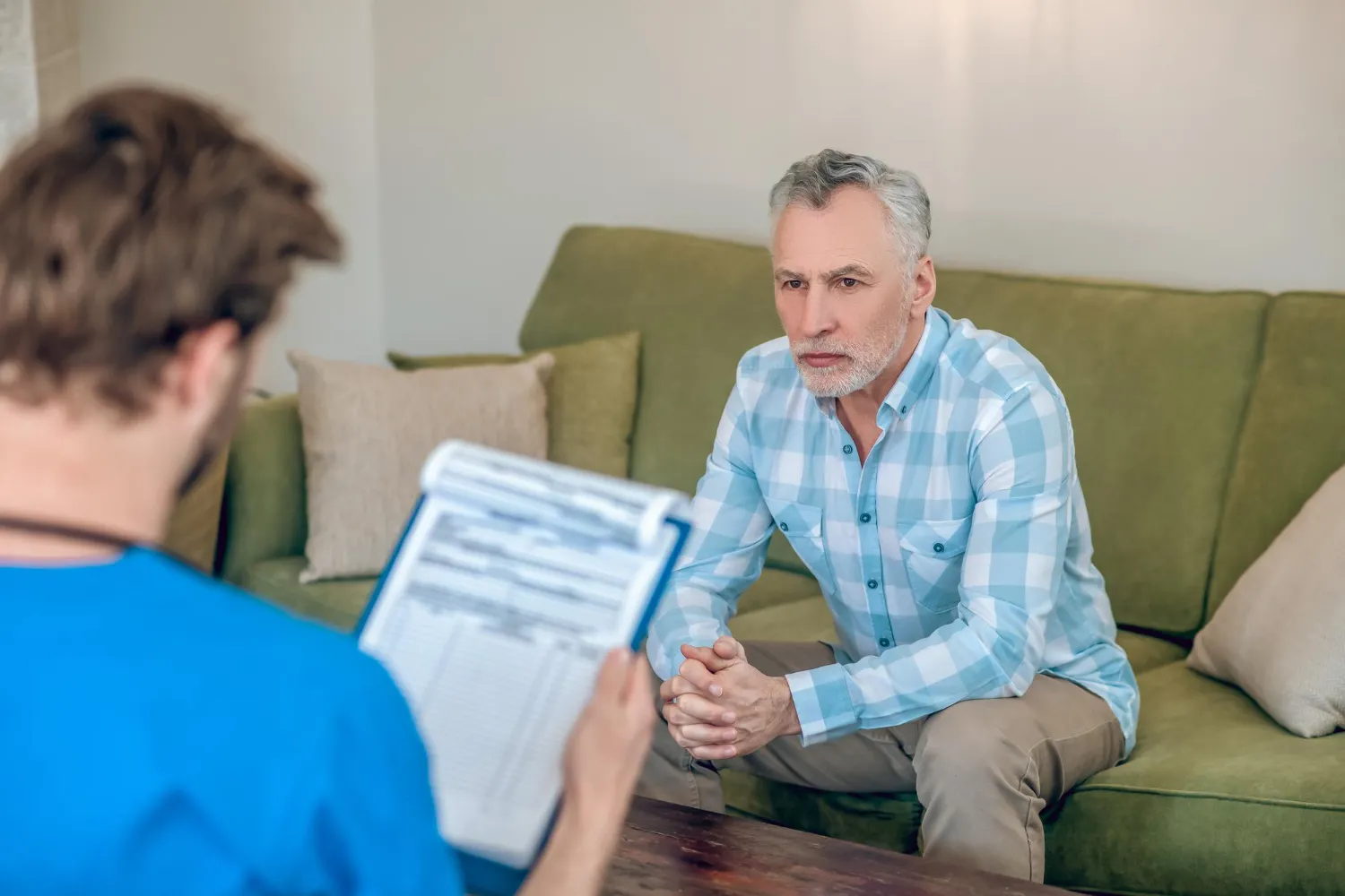 A man speaking with a healthcare professional during a private consultation, highlighting the importance of regular Men’s Health Checkup, health assessments, and personalized care at a Men's Wellness Clinic.